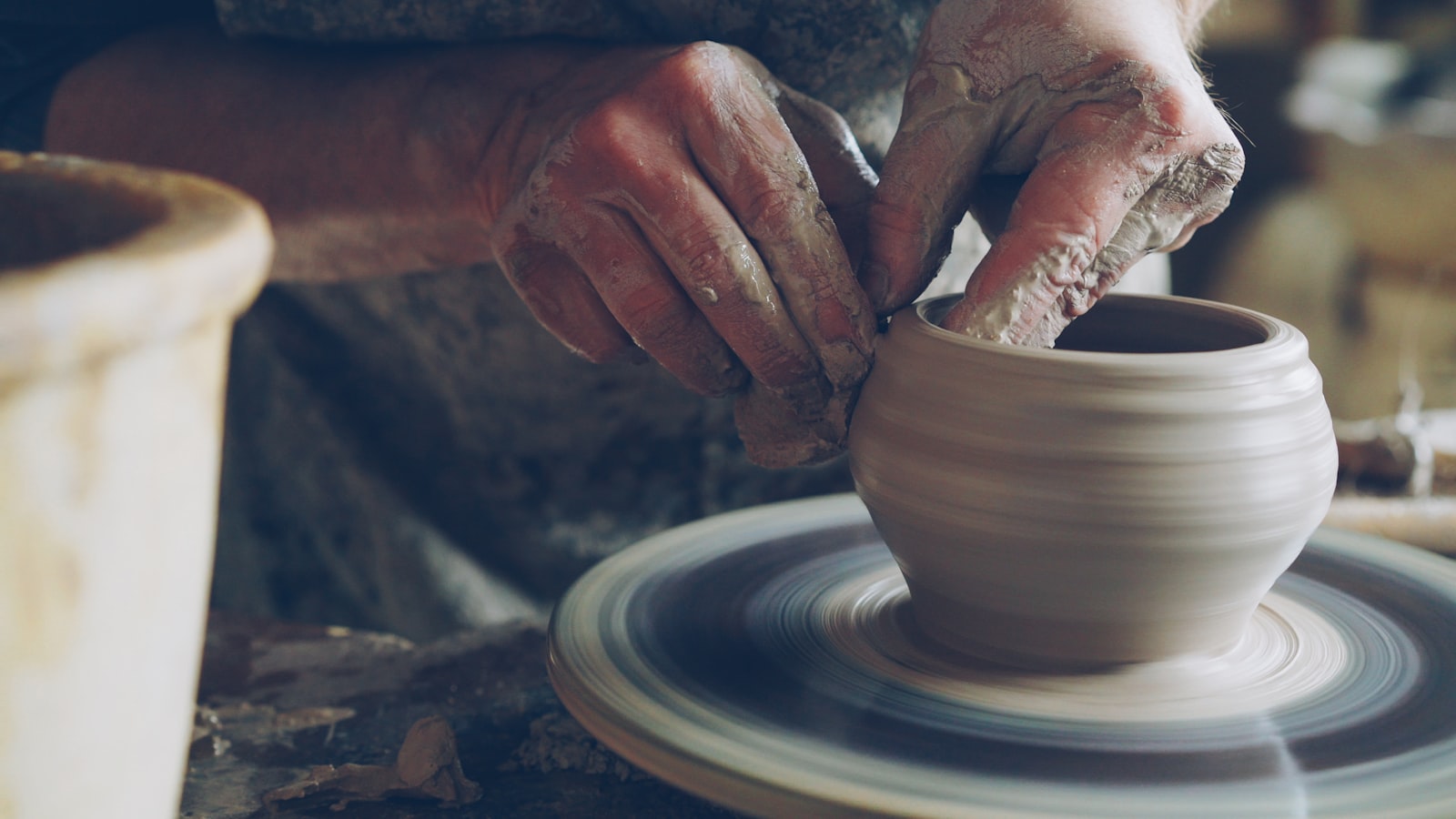 Learning by doing, hands shaping clay on a wheel